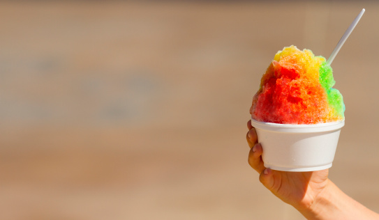 A cold cup of shave ice with bright colors.