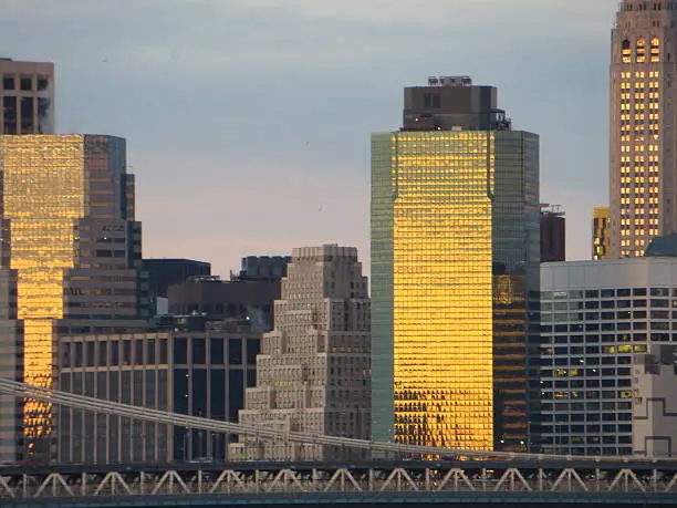A stunning mustard color reflection on Downtown Manhattan at Sunrise in morning of Dec 28 2015, The Manhattan Bridge complement the photo.