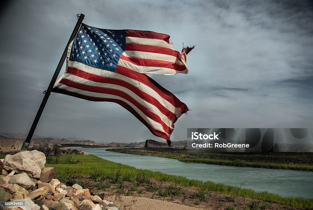 Torn American Flag Torn American Flag flies over the Colorado River with dark storm clouds overhead Torn Stock Photo