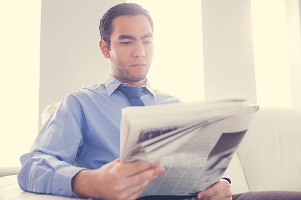 istock Handsome businessman reading newspaper 502936139