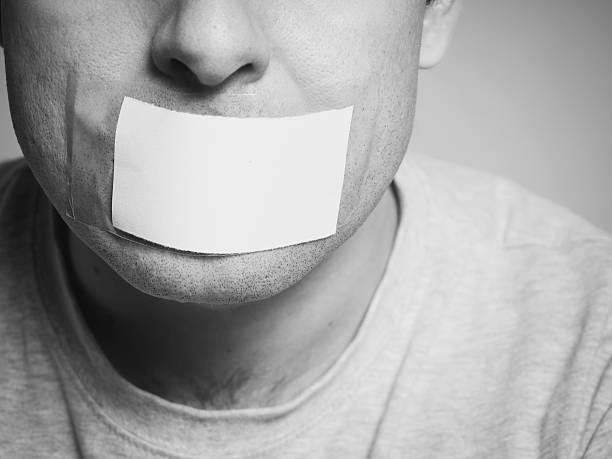 Caucasian man with duct tape on mouth, white . Caucasian man with duct tape on mouth, white . Conceptual image. camera covers pictures stock pictures, royalty-free photos & images
