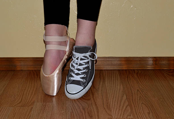 Ballet dancer in ballet shoe and tennis shoe stock photo