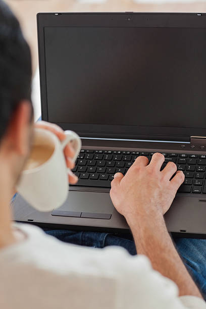 istock Over shoulder view of young man using his laptop 502937541