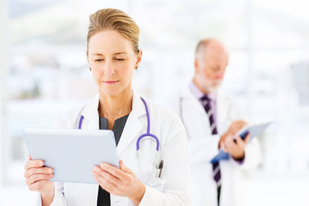 doctora usando tableta digital en el hospital - people female male men fotografías e imágenes de stock