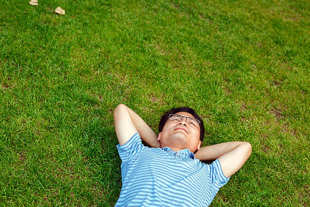 istock Asian man lying on the grassland 502938431