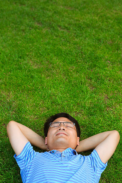 istock Asian man lying on the grassland 502938465