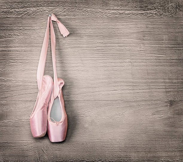 new pink ballet shoes New pink ballet shoes hanging on wooden background.Vintage style. ballet shoe stock pictures, royalty-free photos & images