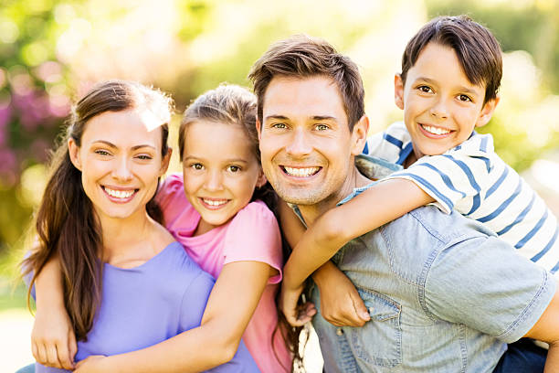 istock Parents Piggybacking Children In Park 502938589