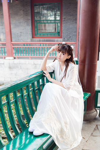 courtyard young girl, wearing a white dress, to enjoy the beautiful scenery