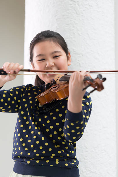 istock Smiling Girl Playing Violin 502945550