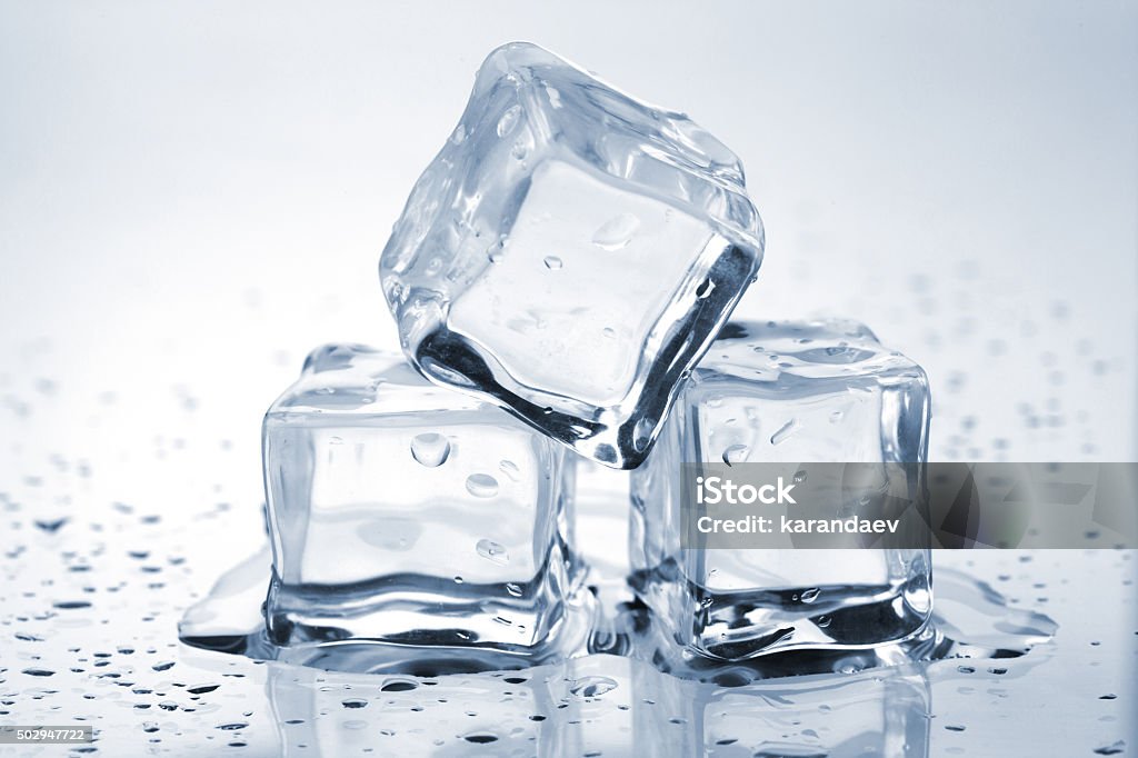 Three melting ice cubes Three melting ice cubes on glass table Ice Cube Stock Photo