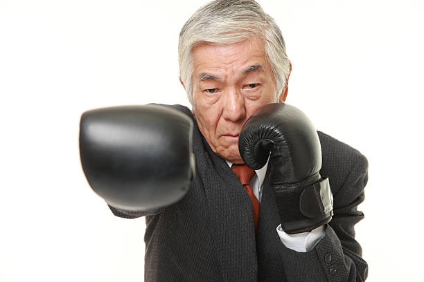 senior homme d'affaires japonais, jetés à droite tout droit - boxing glove battle business fighting photos et images de collection