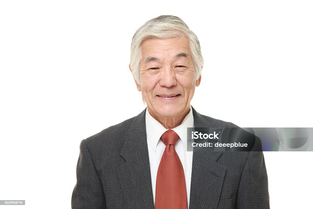 senior Japanese businessman smiles studio shot of senior Japanese businessman on white background 2015 Stock Photo