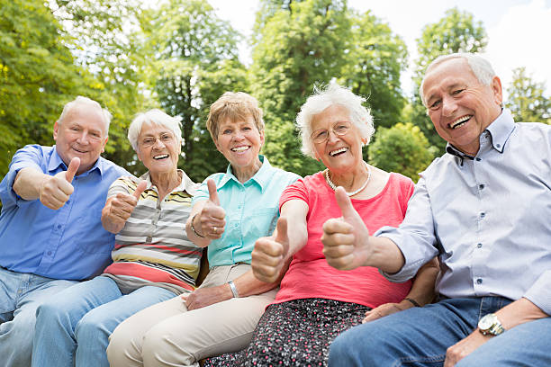 Group of senior adult in the park showing thumbs up Group of senior adult senior adult women park bench 70s stock pictures, royalty-free photos & images