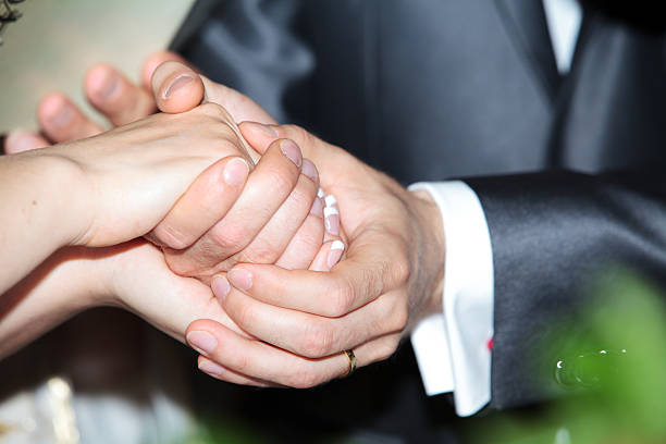 istock Bride and groom holding each others' hands during wedding ceremony 502951061