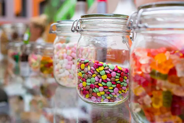 Photo of colorful candys, sprinkles in vintage glass jar