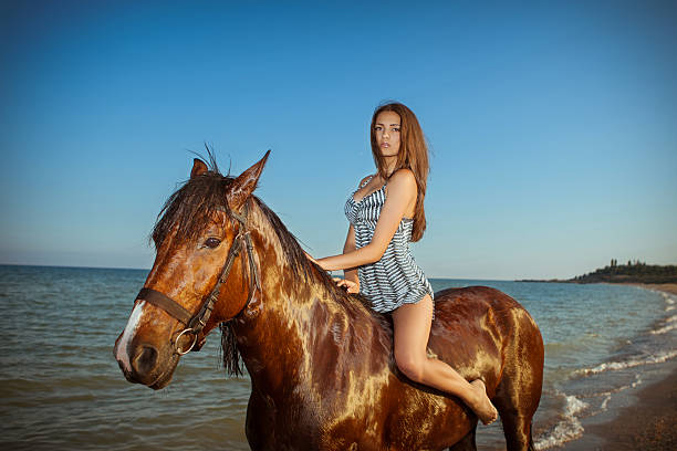 carefree young woman evening beach horse ride