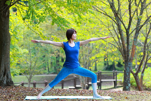 Portrait of Japanewe woman doing yoga exercise outdoor