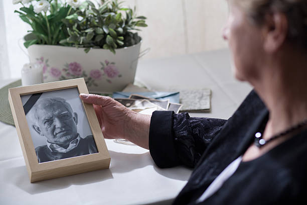 Widow looking at the photo Widow looking at the photo of her dead husband mourner photos stock pictures, royalty-free photos & images