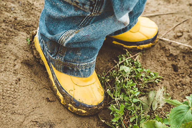 istock Child's boots in a muddy field 502970277