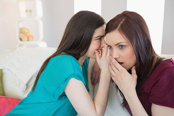 istock Brunette telling her surprised friend a secret 502970403