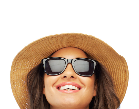 Cropped shot of an attractive young woman wearing a hat and sunglasses isolated on white