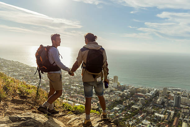 istock Gay hikers holding hands while standing on rocks 502970852