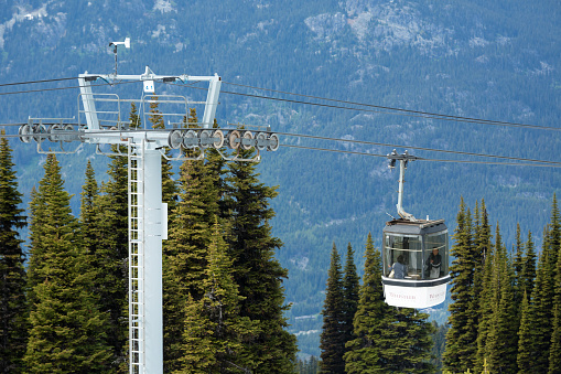 Whistler, Canad - June 11, 2014: Asian tourists enjoying the scenery while riding the cable lift up Whistler Mountain