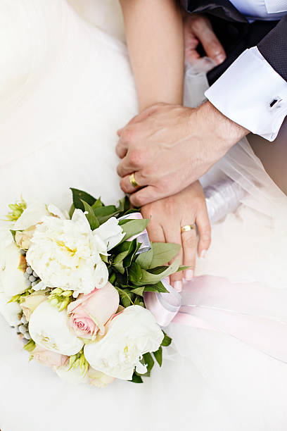 istock Bride and Groom Showing Wedding Rings on Bouquet 502973380