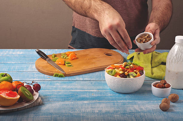 istock Man cooking at home preparing fruit salad 502973750