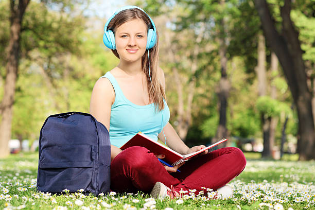 istock Female student reading a book in park 502974957
