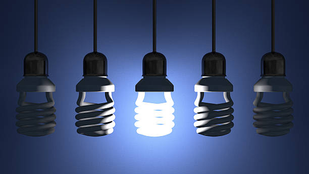 istock Glowing spiral Light bulb hanging among dead ones 502976615