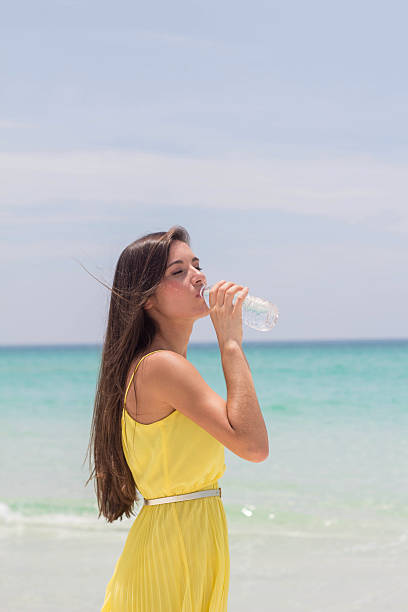 istock Young woman drinking water at the beach 502977141