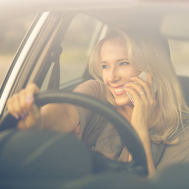 istock Young smiling woman using phone in a car 502989362