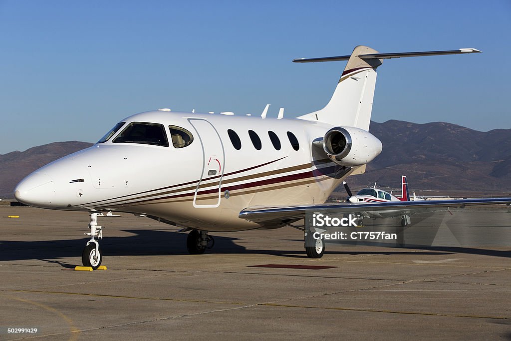 Private Jet A small private jet parked on the airport tarmac. 2000 Stock Photo