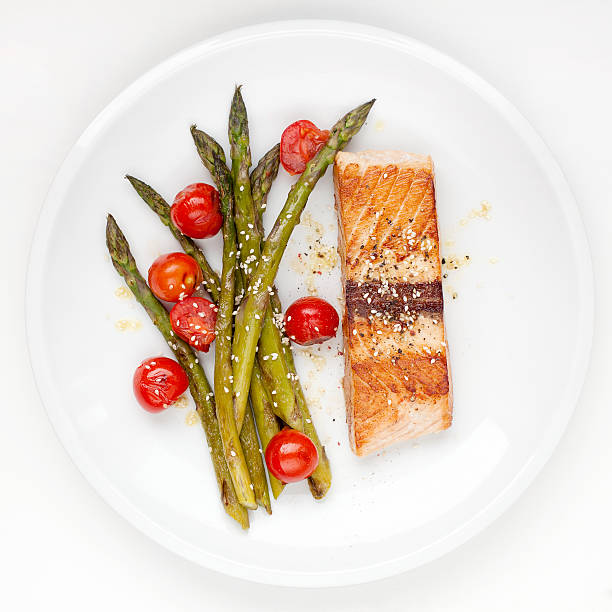 Salmon fillet with asparagus and cherry tomatoes stock photo