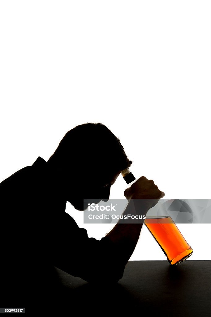 alcoholic drunk man and whiskey bottle alcoholism concept silhouette silhouette of alcoholic drunk man drinking and holding whiskey bottle against his forehead feeling depressed and sad out of alcoholism ,  alcohol addiction and abuse concept isolated on white background vertical composition Abuse Stock Photo