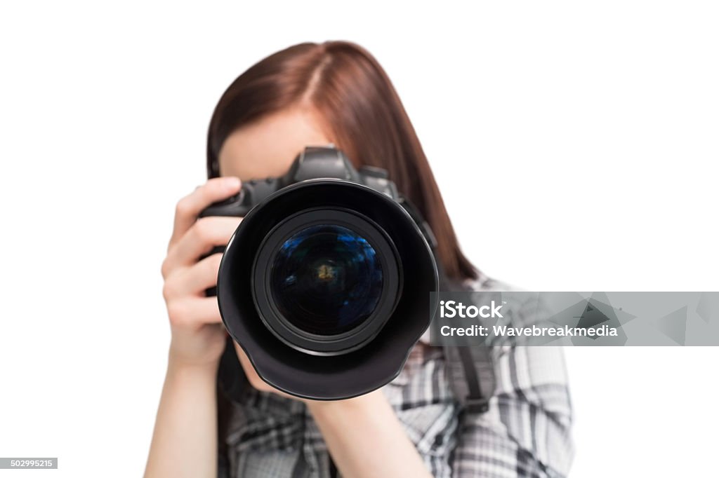 Young casual photographer taking picture of camera Young casual photographer on white background taking picture of camera Adult Stock Photo