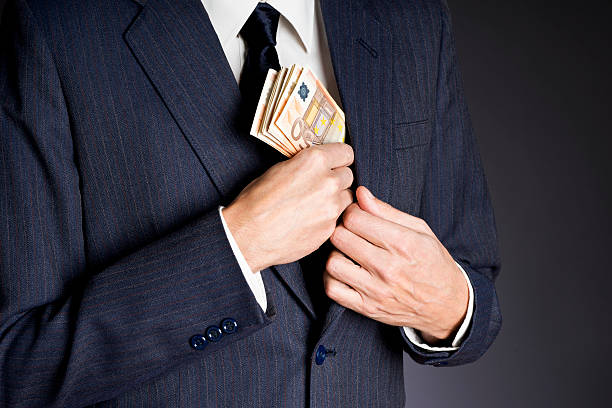 istock Business man putting banknotes  (fifty euros)  in his jacket pocket 502995942