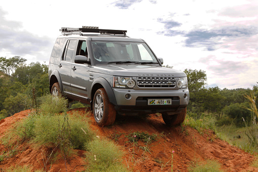 Bafokeng, Rustenburg, South Africa - March 8, 2014: Silver Land Rover Discovery 4 SDV6 S crossing obstacle at Leroleng 4x4 track.