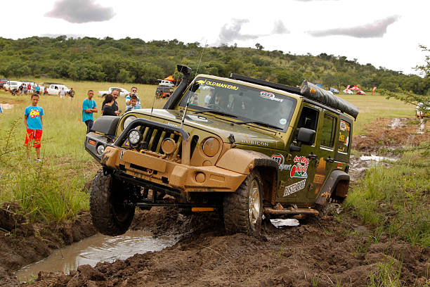 ヤモリパールグリーンのジープラングラールビコン crossing 障害泥 - off road vehicle 4x4 jeep mud ストックフォトと画像
