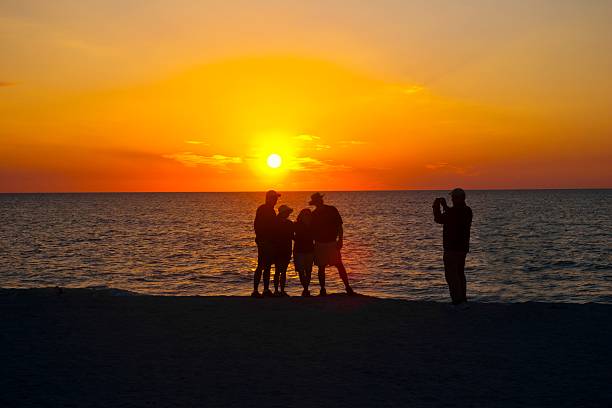 istock Man photographing two couples on the beach 502996490