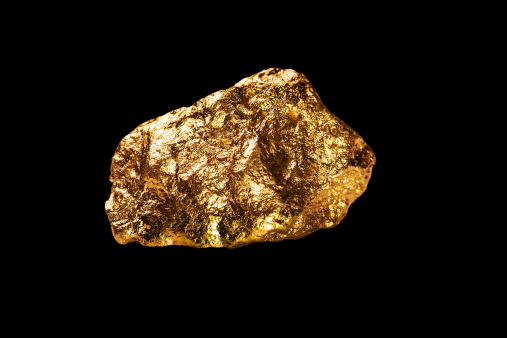 Gold nugget isolated on black background.