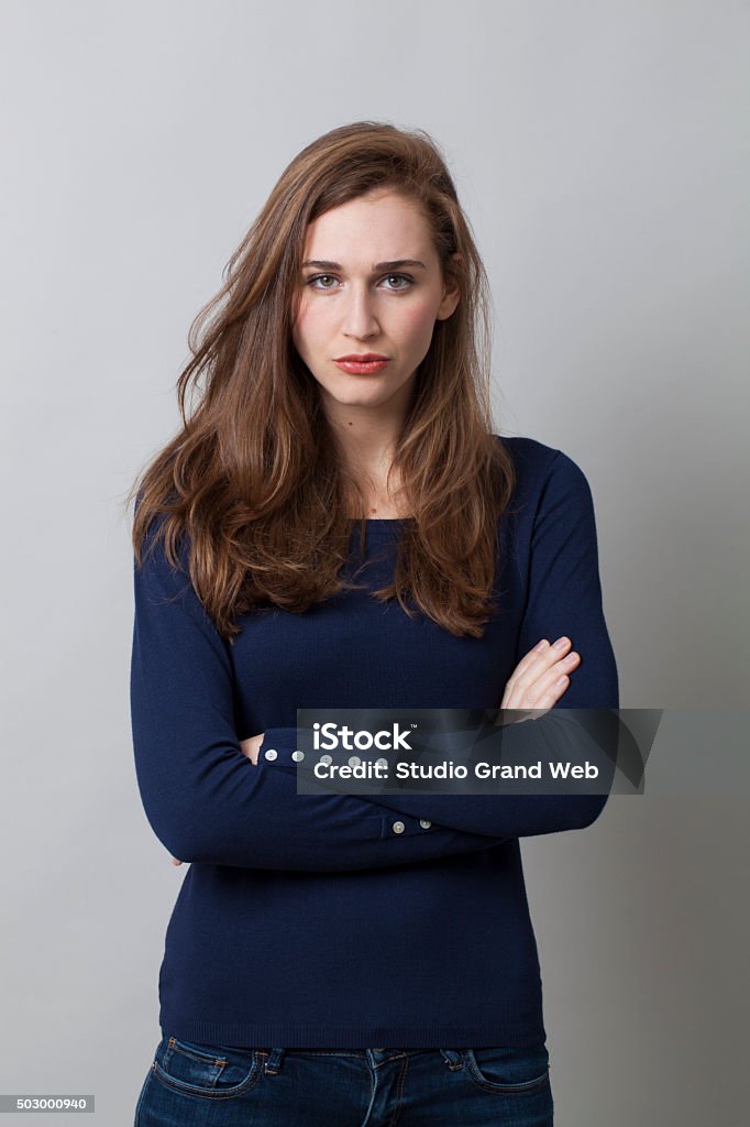 protection concept for displeased beautiful young woman protection concept - displeased beautiful young woman standing with arms folded,studio shot 20-29 Years Stock Photo