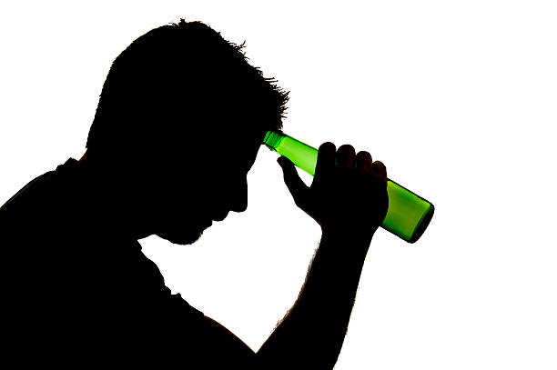 istock silhouette of alcoholic drunk man drinking beer bottle 503006693