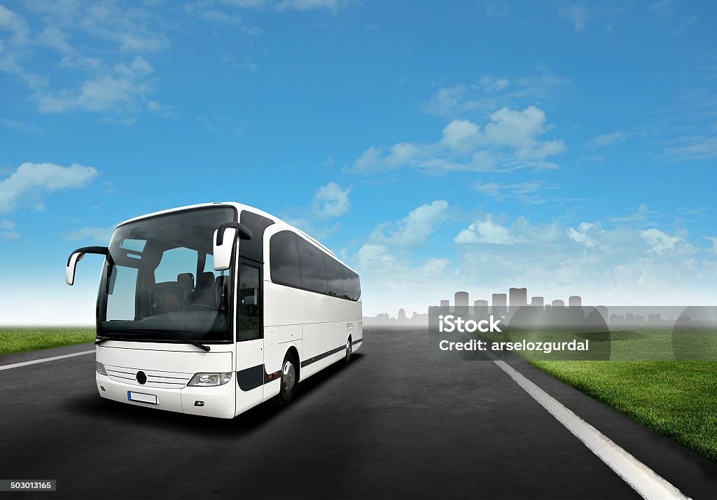 White Bus on the Road White Bus on the Road with city silhouette Coach Bus Stock Photo