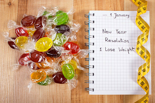 新しい年の解像度で書かれたノートパソコン、キャンディー、巻き尺 - dieting planning calendar event ストックフォトと画像
