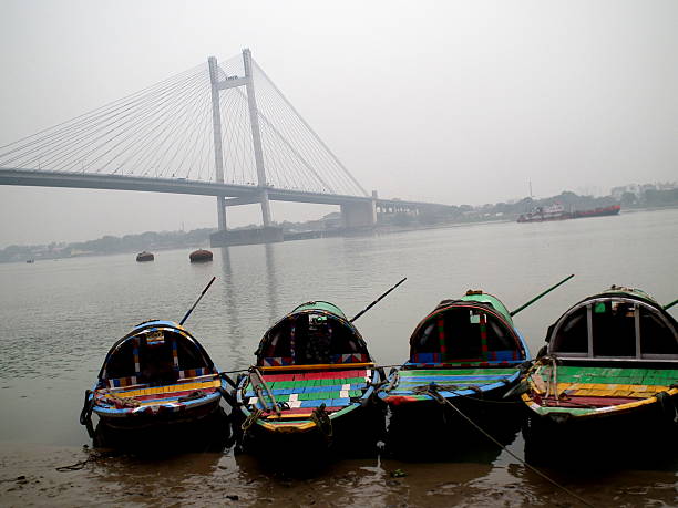 Tourist boats lined together in the river Hooghly at Babu-Ghat, overlooking the famous Second Hooghly bridge.