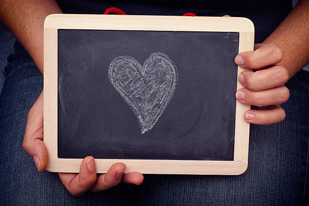 istock Young woman holds blackboard with heart shape on it 503024772