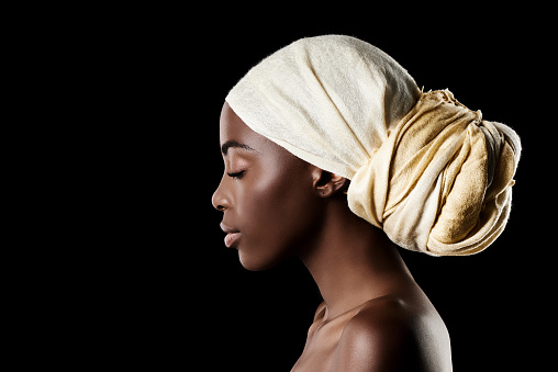 Studio shot of a beautiful woman wearing a headscarf against a black background
